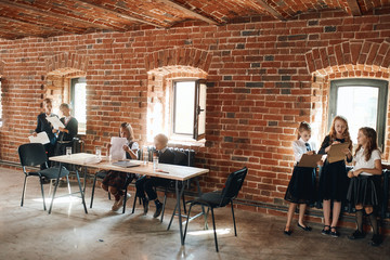 Young business boys and girls working in the office with loft interior, ediucation, full length photo.