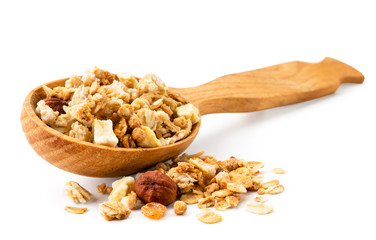 Granola spilled out from a wooden spoon closeup on a white. Isolated