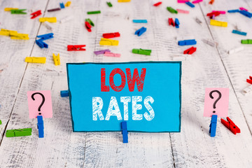Word writing text Low Rates. Business photo showcasing A cost of an item or service which is usualy at its smallest price Scribbled and crumbling sheet with paper clips placed on the wooden table