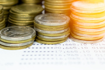 close-Up Many coins are stacked on bank account passbook, Money saving concept.