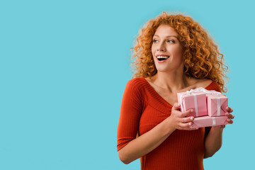 happy woman holding gifts isolated on blue