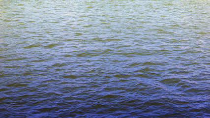 Water surface background with gradient abstract light effect on top. Blue water pattern with soft light. Nature wallpaper with blank copy space for text 