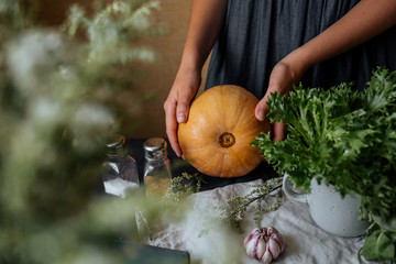 Girl in a cotton blue dress with a pumpkin in her hands