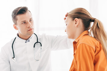 pediatrist in white coat taking temperature of child