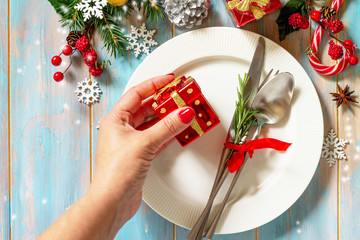 Christmas table setting. Festive plate and cutlery with decor on festive table. Top view flat lay.