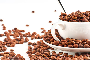 Background of coffee beans and coffee Cup with saucer isolated on white background.
