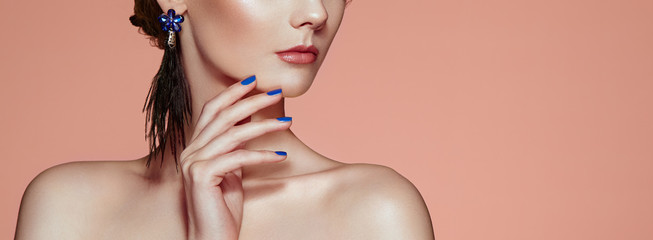 Beautiful woman with large earrings tassels jewelry blue color. Perfect makeup and nails manicure