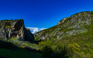 Fototapeta na wymiar valley between rocks with grass and bushes