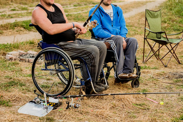 Obraz premium Handicapped men fishing at a lake. Wheelchair. Camping.