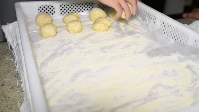 children's hands put dough balls on a stand to make Italian panzerotti pies. Cooking Panzerotti in Puglia, Salento, Italy