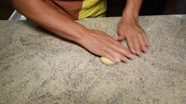 old woman's hands make dough balls to make panzerotti pies, a traditional dish in Salento, Puglia, Italy