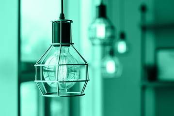 Loft style light bulbs glowing near window. Coffee shop interior.