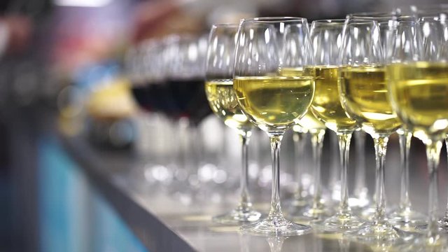 Glasses of white wine on a rack prepared by the bartender for guests and participants of the festive event. Close-up, soft focus, bokeh. Catering and alcoholic drinks are a treat at the holiday.