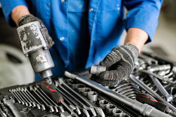 Gloved engineer of contemporary machine repair service with work tool