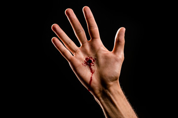 cropped view of religious man with bloody hand isolated on black - obrazy, fototapety, plakaty