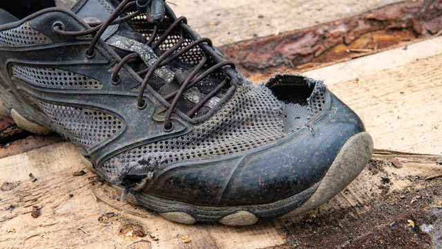  torn old shoes on the background of boards