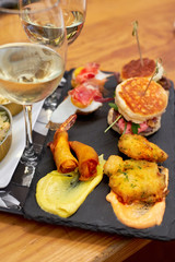 A set of traditional portuguese snacks with codfish, mussels, octopus with a glass of vinho verde