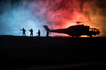 Fototapeta na wymiar Silhouette of military helicopter ready to fly from conflict zone. Decorated night footage with helicopter starting in desert with foggy toned backlit. Selective focus.