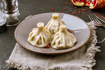 Khinkali with lamb on black concrete table. Georgian cuisine.