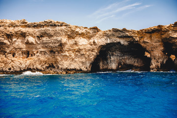 Fototapeta na wymiar Panorama beach Blue Lagoon Comino Malta. Rocky coast with window and arch Mediterranean Sea