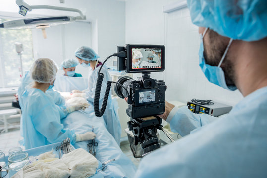 The Videographer Shoot The Surgeon And Assistants In The Operating Room With Surgical Equipment.