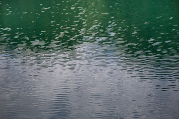 Close up detail of water surface with ripples on it.