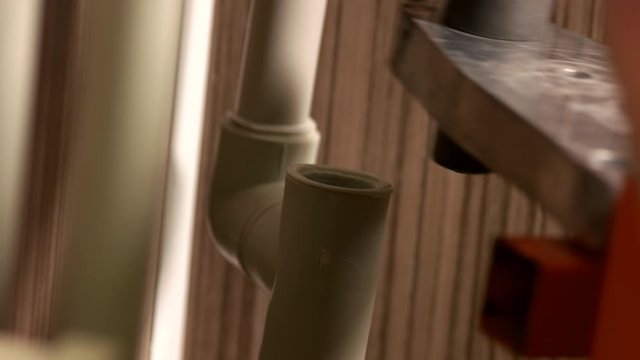 Close up of plumber working with pipes. Plumber installing plastic water pipes. Plumbing installation concept.