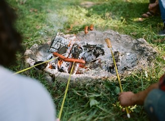 Cooking hotdogs over a camp fire