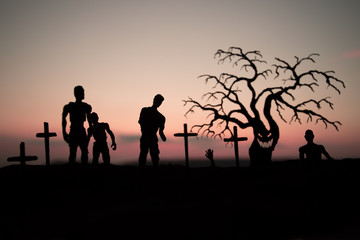 Silhouette some zombies on the cemetery walking around at sunset. Selective focus