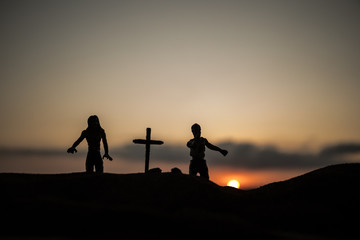 Fototapeta na wymiar Silhouette some zombies on the cemetery walking around at sunset. Selective focus