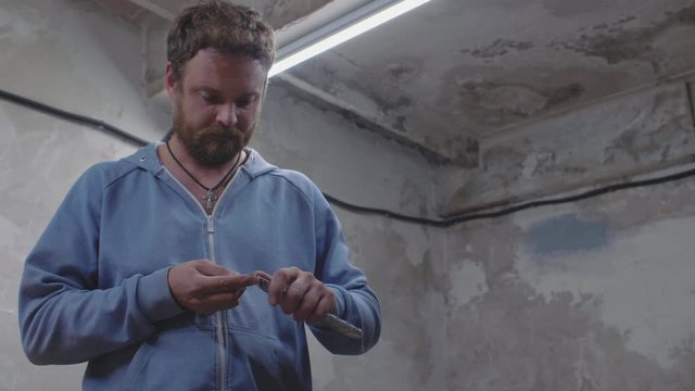 worker with a beard in the workshop sharpens a pencil with an office knife. 4k. 4k video. 60 fps