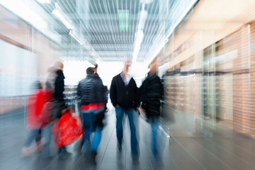 Large group of real people walking indoors, shopping spree