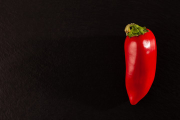 Paprika on black background with side lighting.