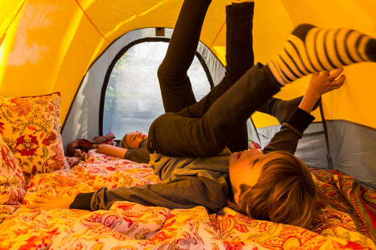 6 year old boy playing inside  yellow tent at sunset