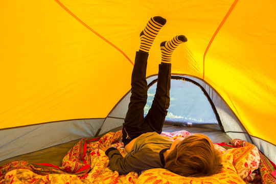 6 year old boy playing inside  yellow tent at sunset
