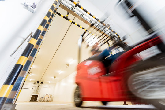 Forklift in a large industrial freezer warehouse. Empty warehouse for vegetable storage.