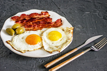 Fried eggs with bacon in a pan. Classic bacon and eggs. Keto Diet LCHF Keto breakfast. Low carb diet concept. high fat diet.  Fried eggs and crispy bacon closeup