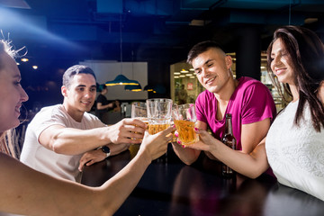 Cheerful friends in the pub. Drinking beer, talking, having fun.
