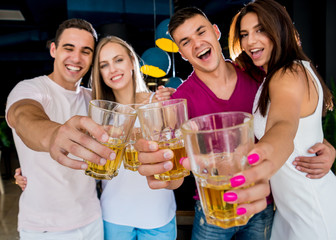 Cheerful friends in the pub. Drinking beer, talking, having fun.