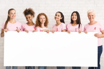 Women In Pink T-Shirts Holding White Board Over Brick Wall