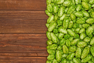 Fresh green hops on a wooden background. Ingredient for beer production. Top view with copy space