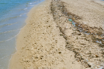 Dirty beach with small plastic debris along the coastline - Tunisia, Sousse, El Kantaoui 06 19 2019