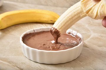 Dipping a banana in chocolate sauce