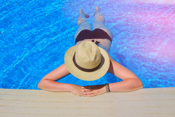 Girl in a straw hat near the water's edge, top view
