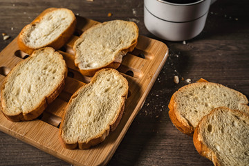 bread for breakfast, with cup of coffee over rustic wooden background with copy space. Morning breakfast with coffee and toasts.