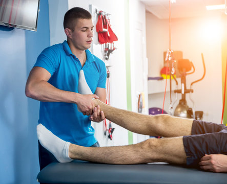 Rehabilitation therapy. Physiotherapist working with young male patient in the rehabilitation center