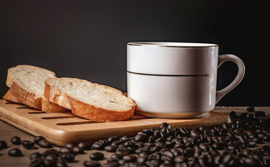 bread for breakfast, with cup of coffee over rustic wooden background with copy space. Morning breakfast with coffee and toasts.