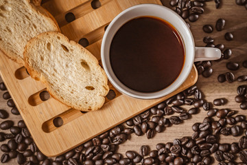 bread for breakfast, with cup of coffee over rustic wooden background with copy space. Morning breakfast with coffee and toasts.