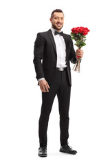 Man in a suit holding a bunch of red roses