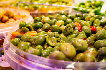 Homemade pickled green olives with garlic and spices on spanish market